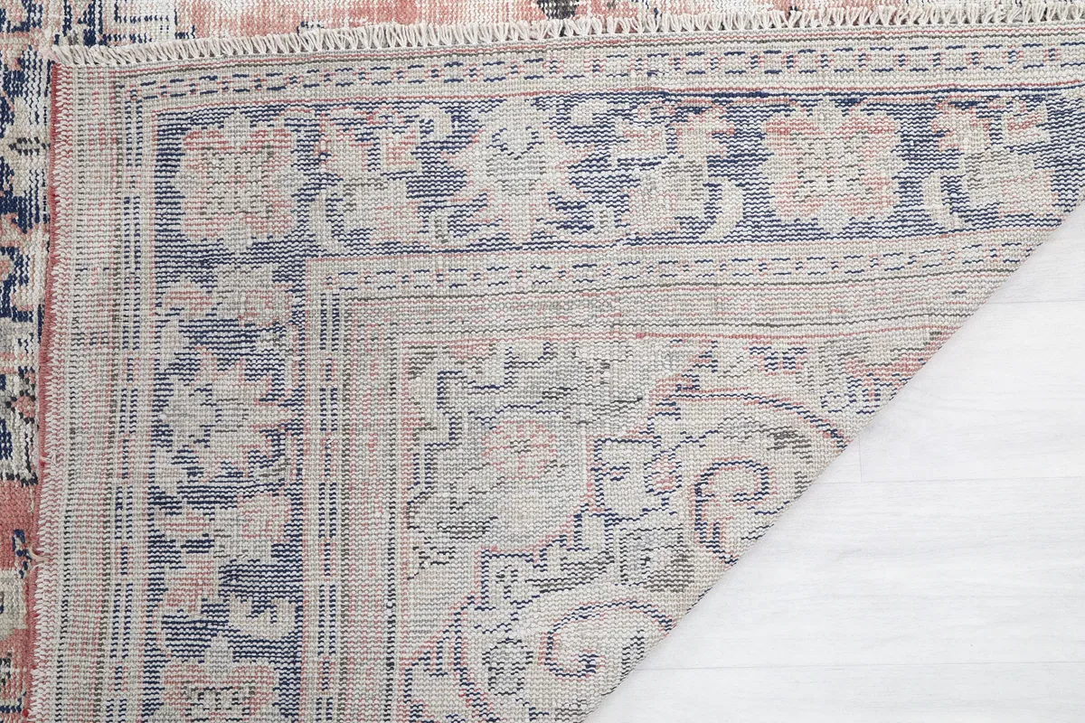 Faded Rose Medallion Vintage Rug corner flipped to reveal the hand-knotted construction on the back.