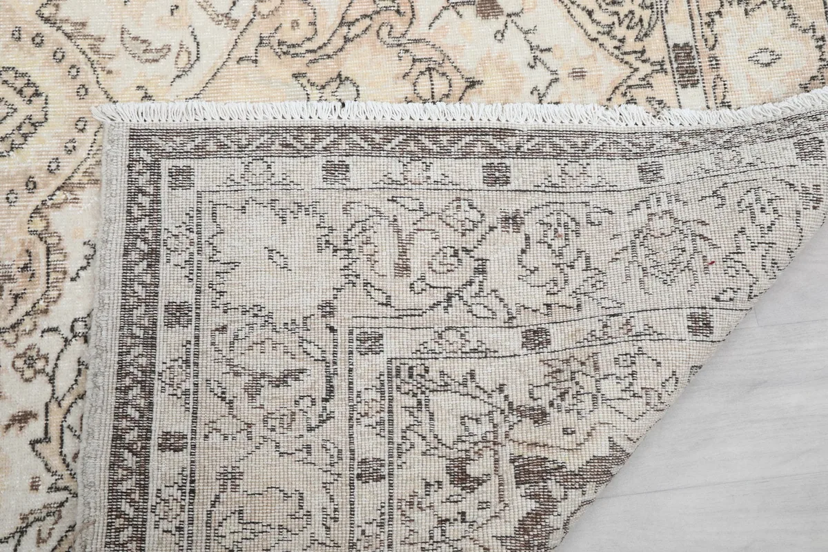 Detail of the short cream fringes and the edge of the hand-knotted rug