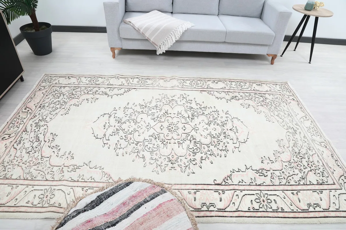 Full room shot with the ivory rug as a focal point, complementing a light-colored sofa.