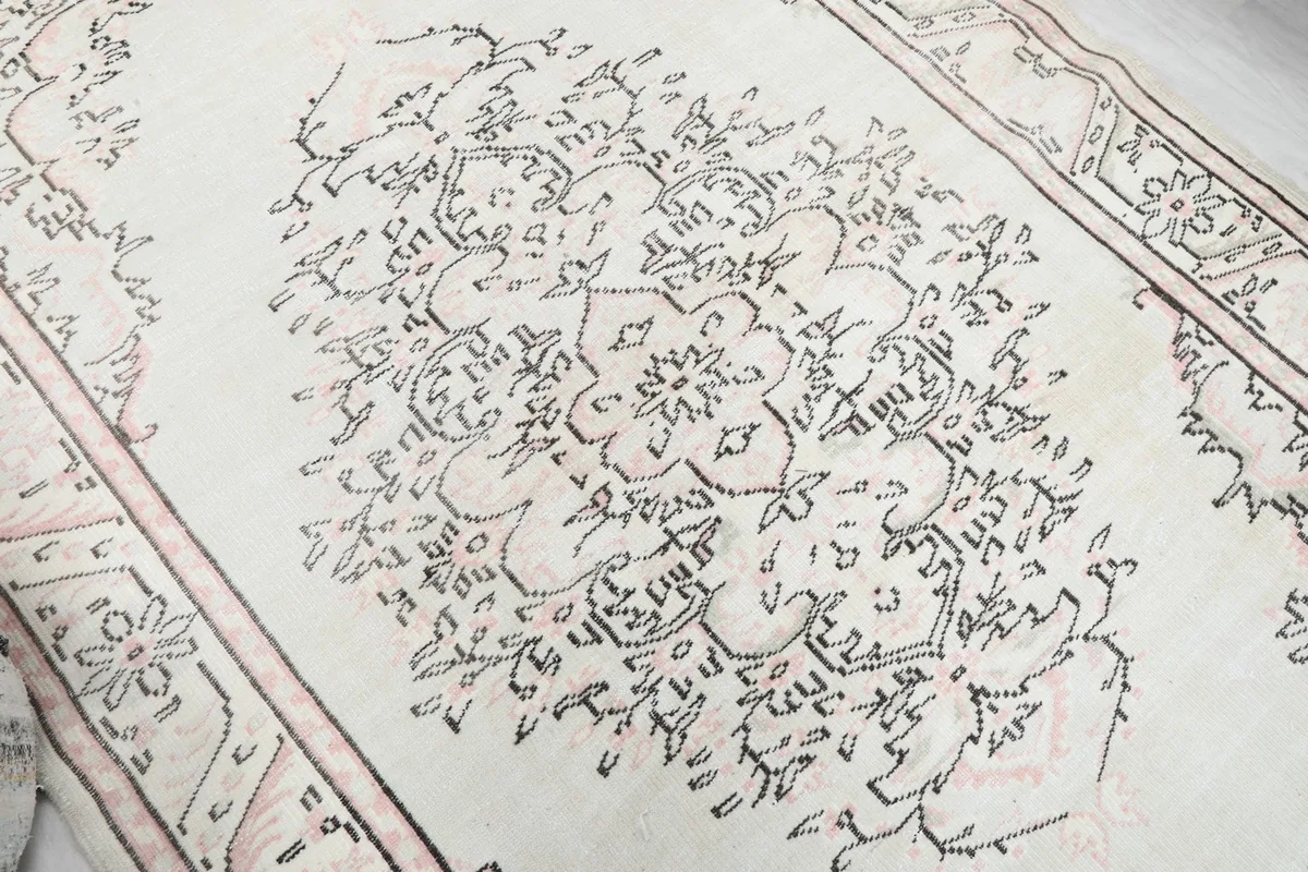 Detailed view of the central medallion and surrounding floral motifs on the ivory field.