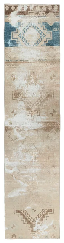 Full overhead view of the beige, brown, and blue geometric runner on a white background.