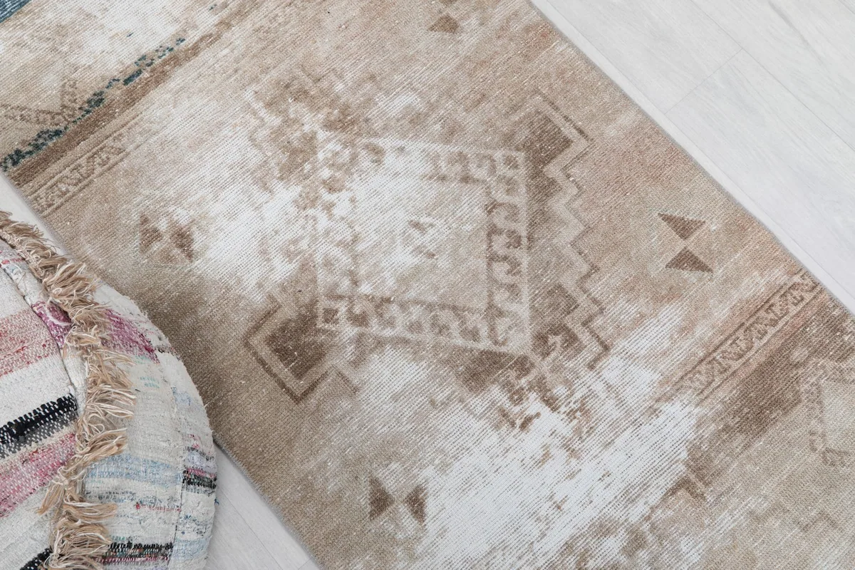 Close-up of the central geometric diamond motif in beige and brown.