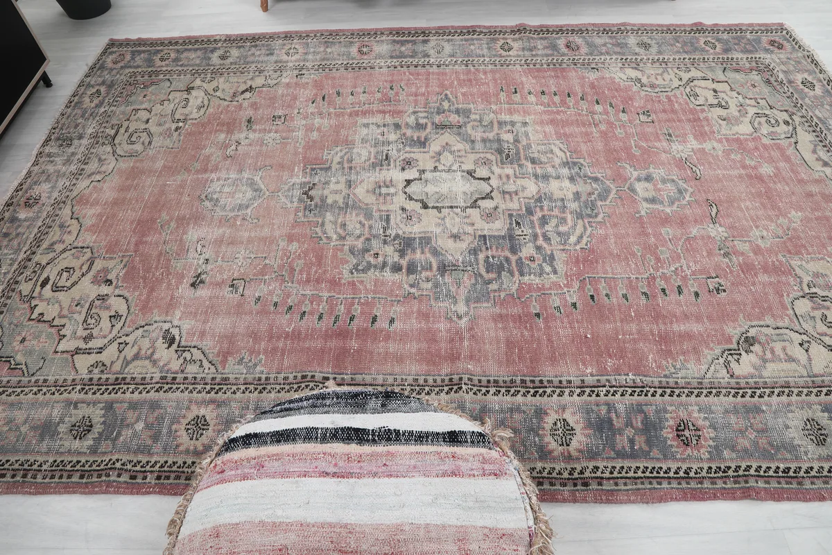 Rose Medallion Anatolian Rug in a room with an ottoman in the foreground, showing its large size.