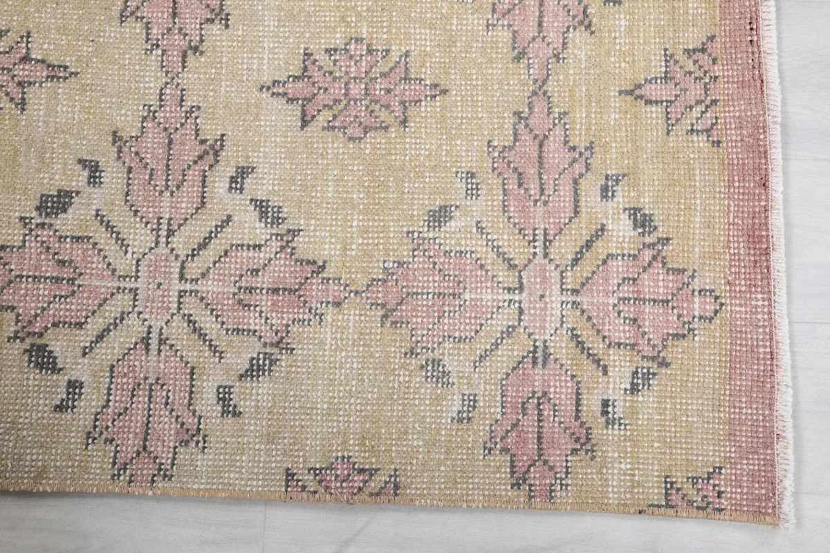 Close-up of the rug's edge, revealing the rose border and geometric pattern