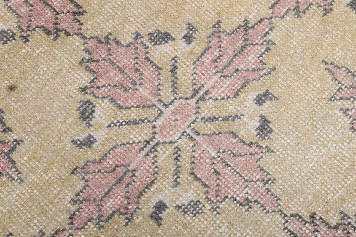 Extreme close-up of a single rose and gray geometric motif, showing knot detail and low pile