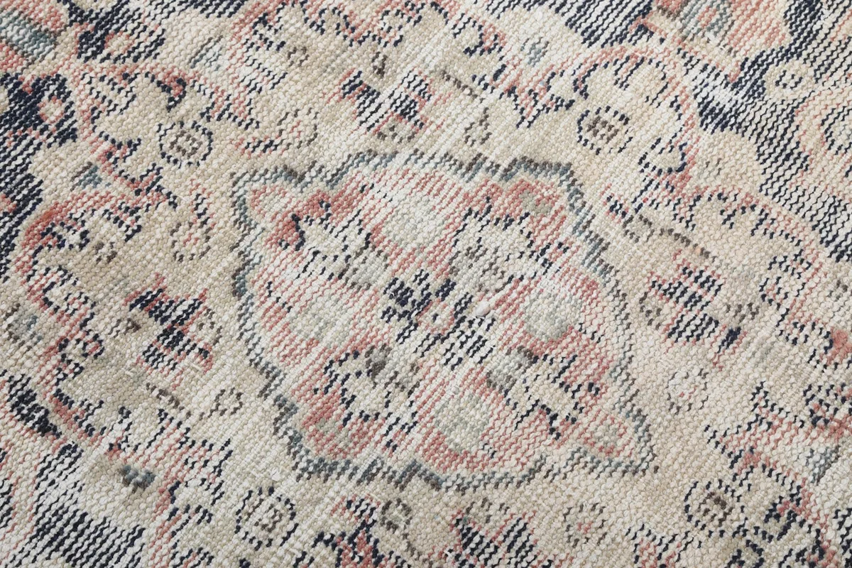 Close-up of the low wool pile, showing the hand-knotted texture and color variations.