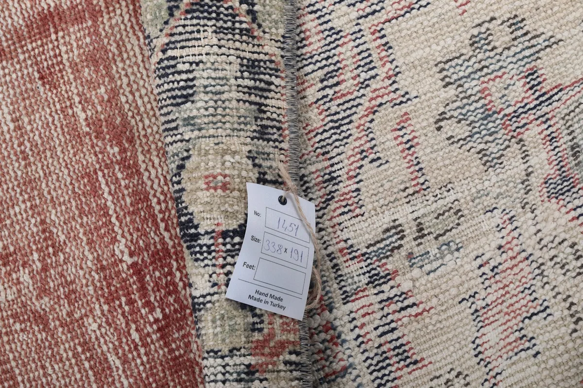 Folded rug showing the tag with product information, highlighting the hand-knotted quality.