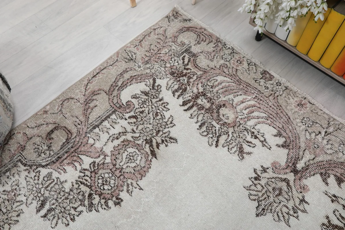 Corner detail of the rug's border, highlighting the faded rose and tan motifs