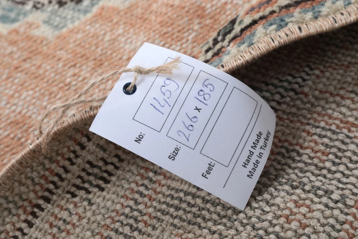 Product tag showing the rug's dimensions and 'Hand Made in Turkey' label