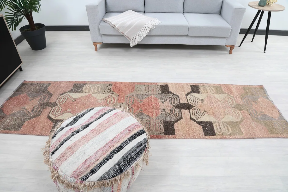 Full length view of the runner in a living space, with a sofa and ottoman nearby.