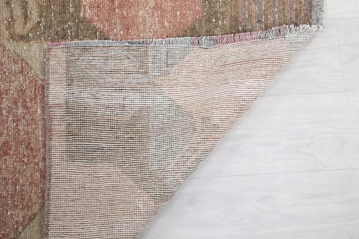Corner of the runner flipped over, showcasing the tightly woven cotton foundation and fringe detail.
