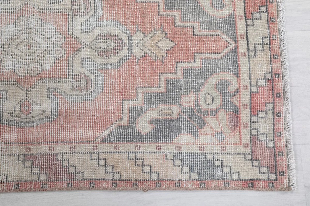 Detail of the runner's corner, showing the geometric border and faded rose field