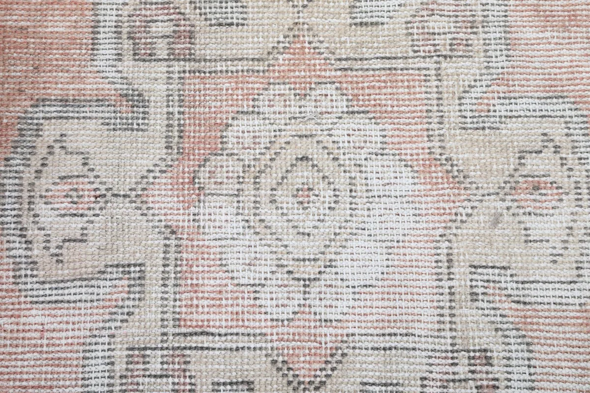 Tight close-up showing the low wool pile and hand-knotted texture of the rug