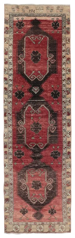 Full overhead view of a vintage red tribal runner rug with black and beige details