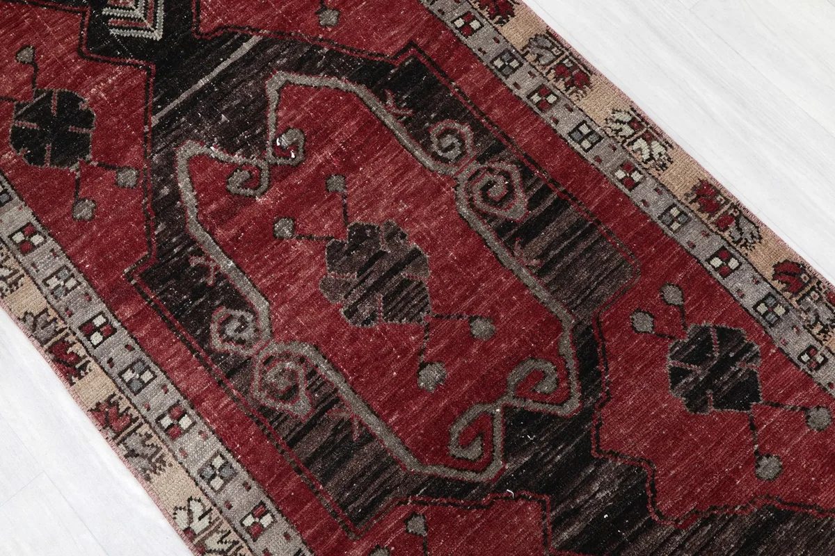 Close-up of the central red field and black geometric motifs with natural wear