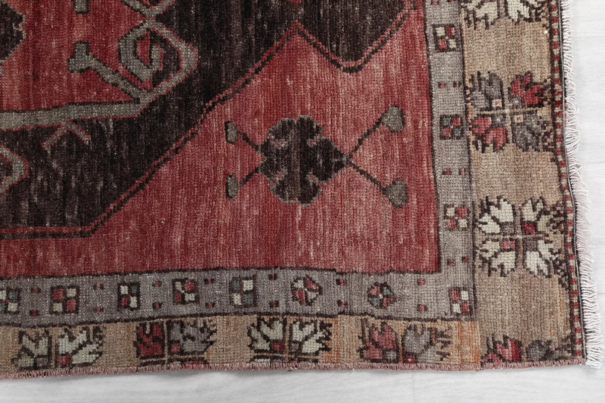 Detail of the beige and gray border pattern and edge of the vintage rug