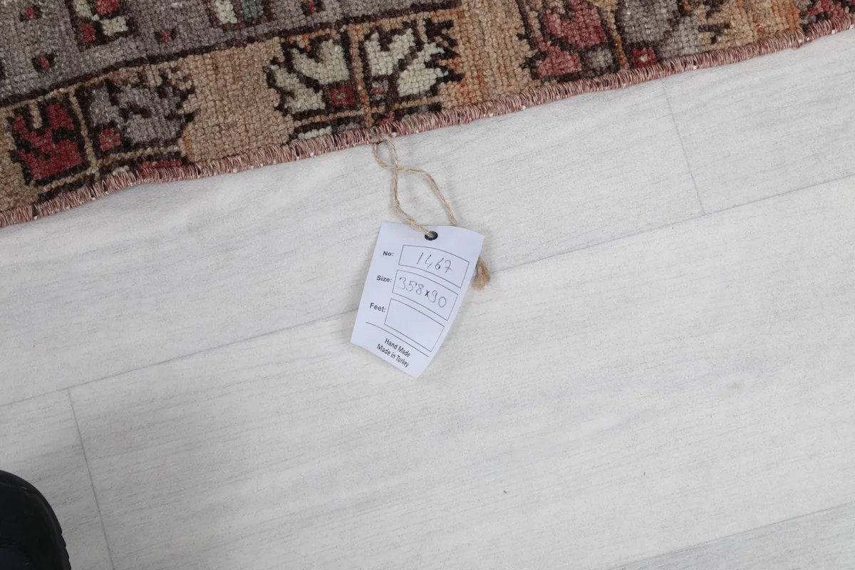 Close-up of the product tag attached to the vintage Anatolian runner rug