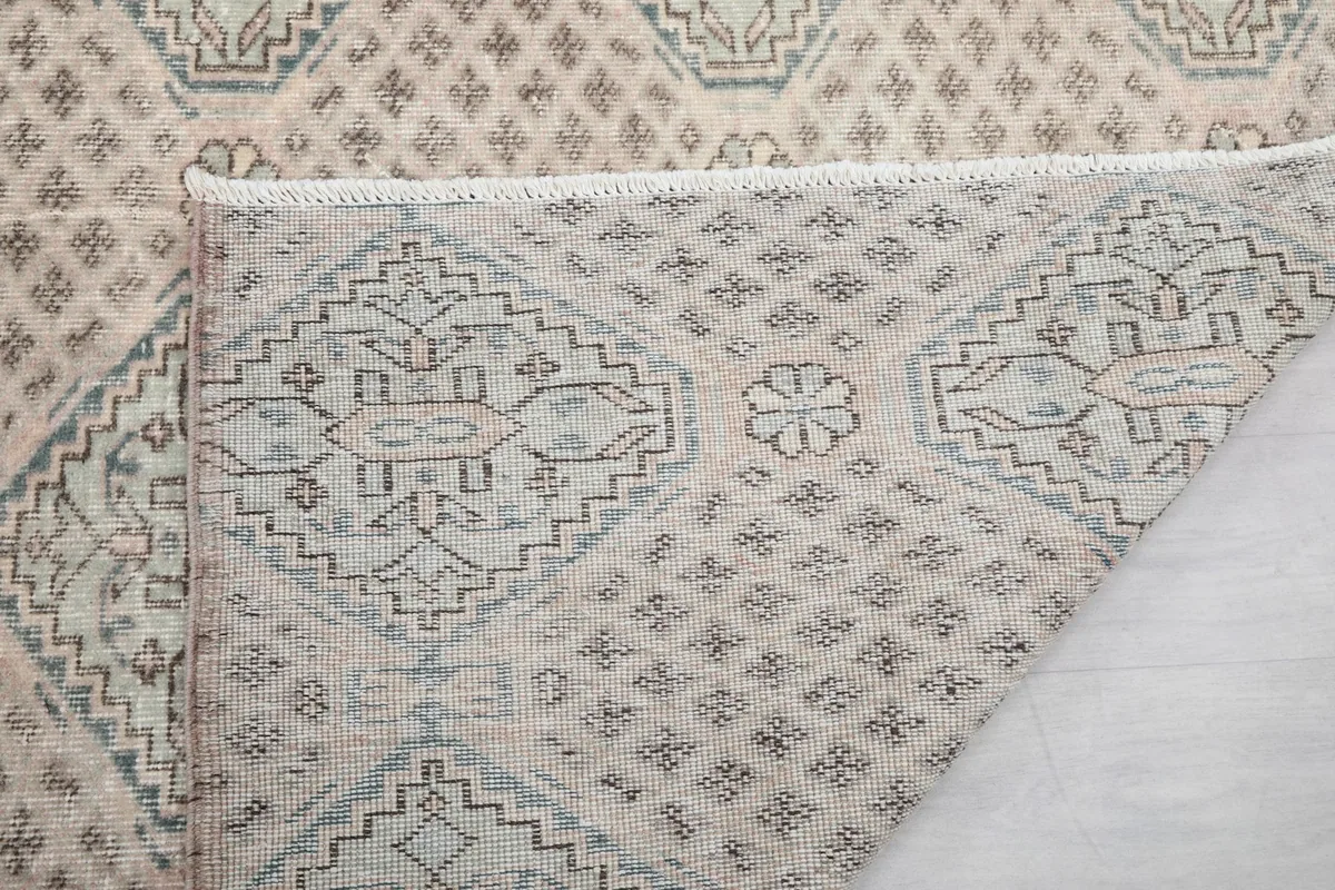 Close-up of the folded corner, showing the intricate hand-knotting and the texture of the wool pile.