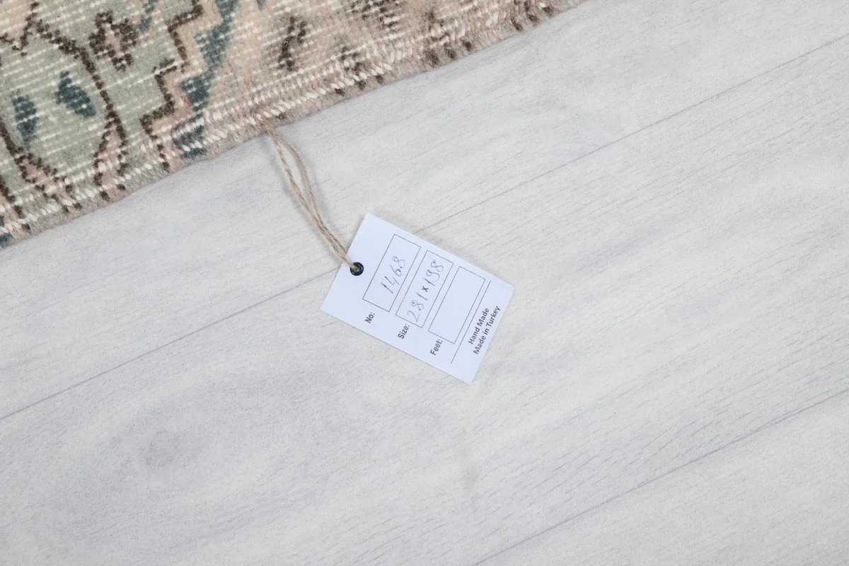 Product tag on a white floor, displaying rug dimensions and origin details.