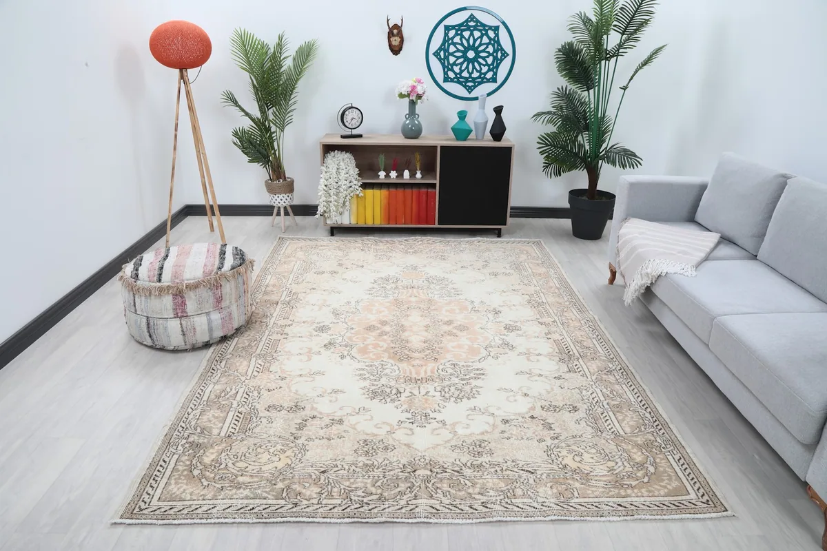 Vintage Anatolian area rug with ivory and rose tones placed in a modern living room setting