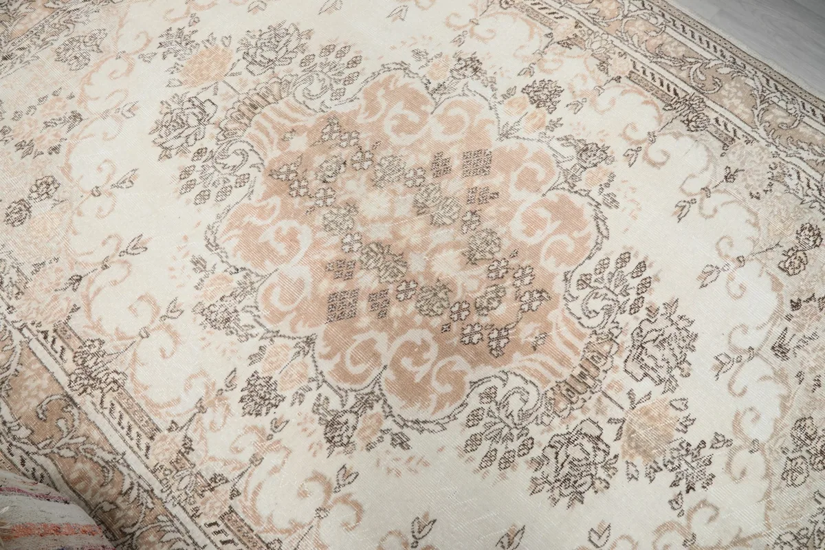 Detailed view of the central rose medallion and surrounding floral motifs on the rug