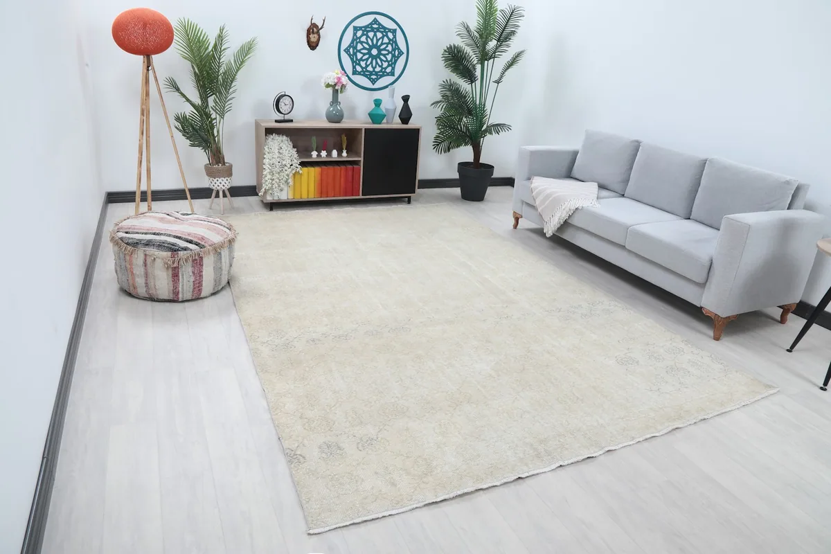 Overhead angle of the cream Anatolian rug in a staged living room, showing its large scale.