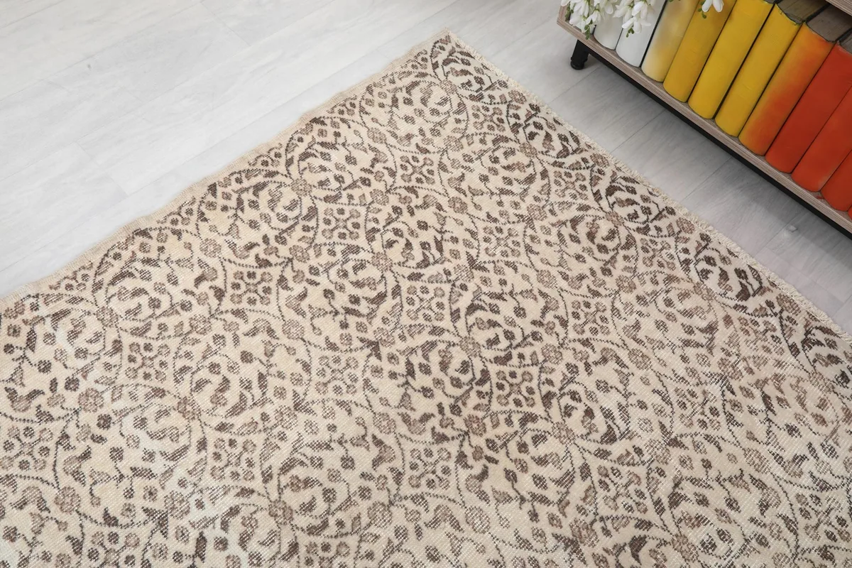 Corner view of the rug's pattern, showing the aged texture and craftsmanship