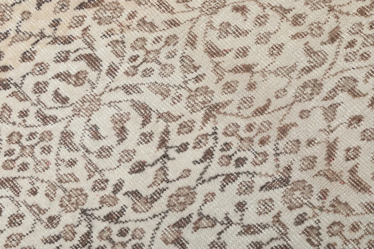 Detailed view of the intricate gray and brown floral motifs and low pile texture