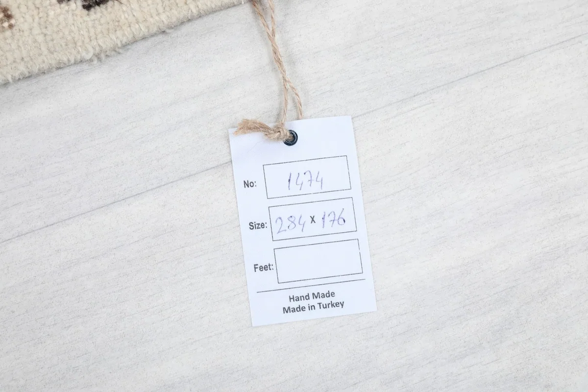 Product tag attached to the rug, displaying its dimensions and origin: Hand Made in Turkey