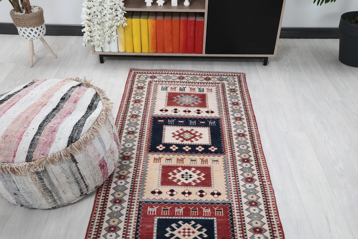 Overhead view of the vintage runner rug in a room, showing its placement in front of a cabinet.
