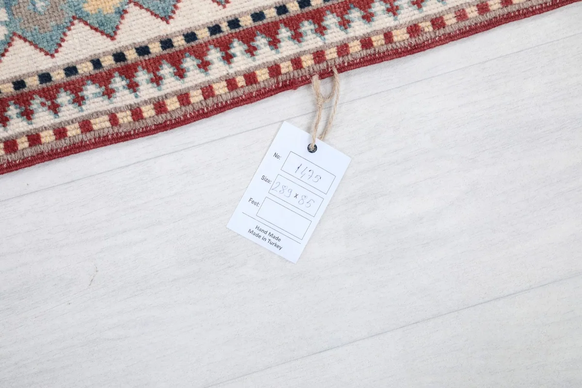 Rug tag displaying size and origin details, placed on the floor next to the rug.