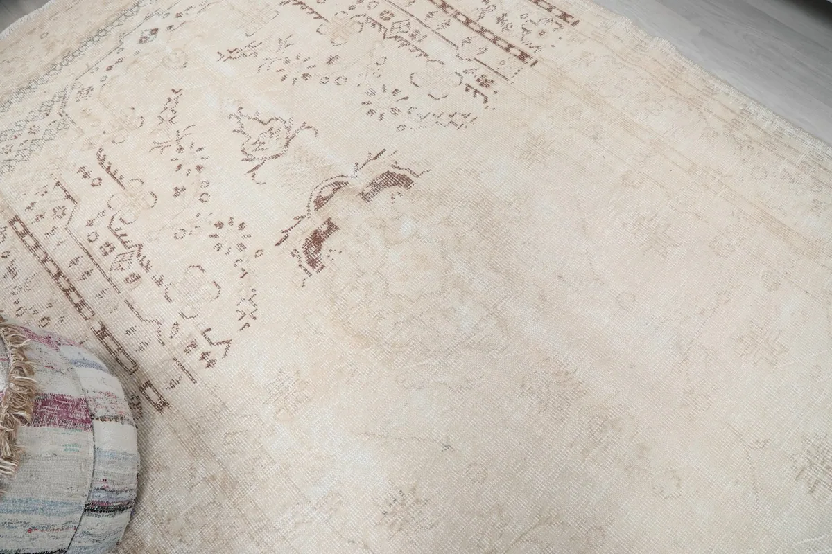 Close-up angle of the rug's central design, highlighting the muted rust and ivory tones