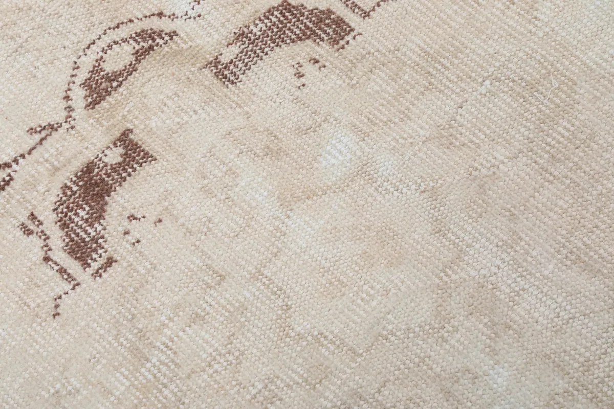 Texture detail of the low pile wool surface, showing the faded colors and hand-knotted weave