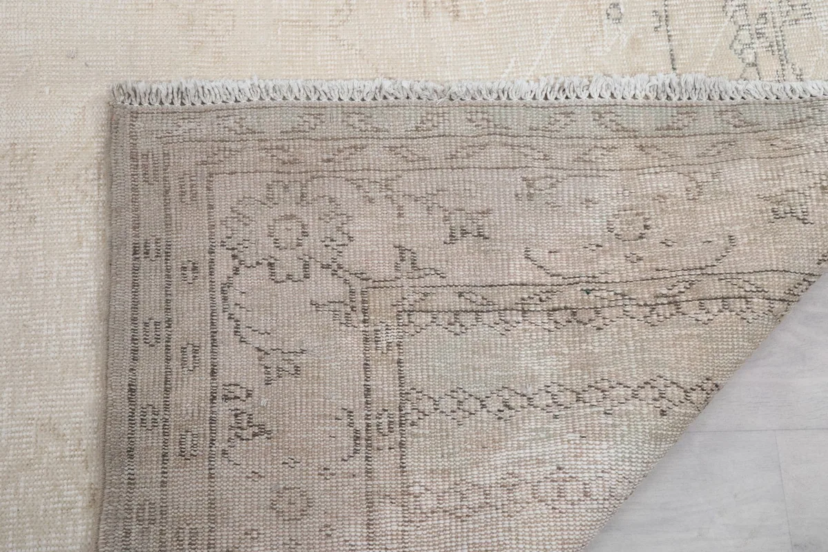 Close-up of the rug's back, showing the consistent knotting and fringe attachment