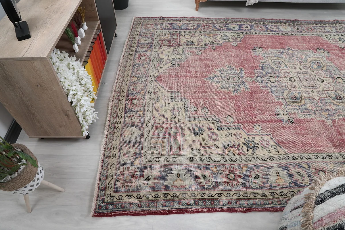Another room view of the large vintage rug, showing its scale relative to furniture