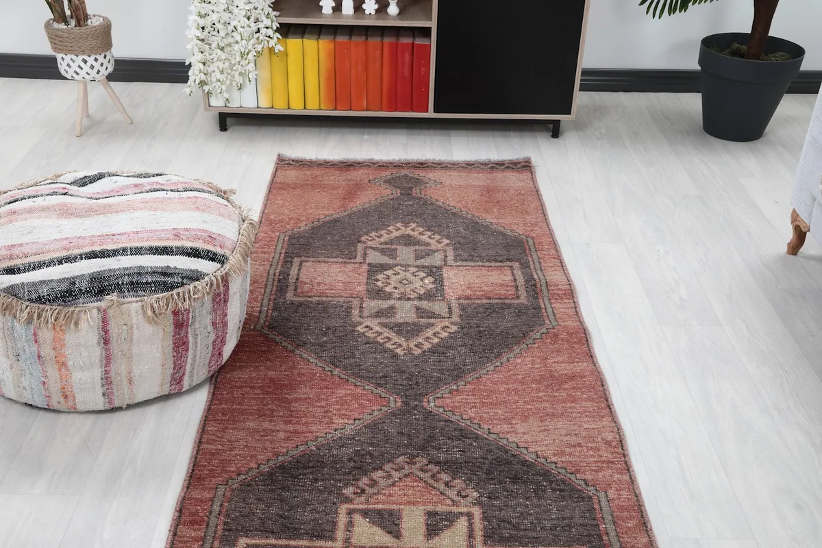 View of the runner rug from one end, showing its placement in a room with a cabinet.