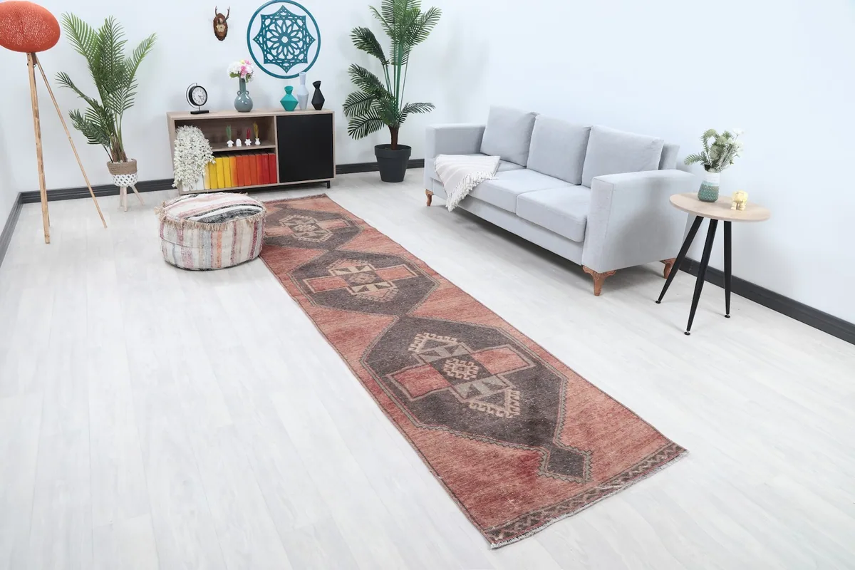 Angle view of the rose and charcoal runner rug extending through a living space.