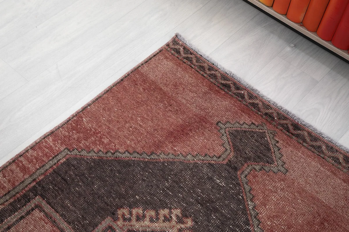 Corner detail of the rug, highlighting the subtle border pattern and faded rose field.