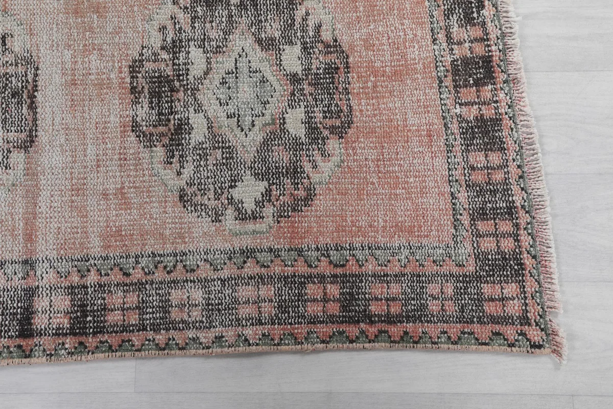 Detailed view of the runner's end, highlighting the rose field and charcoal gray border pattern