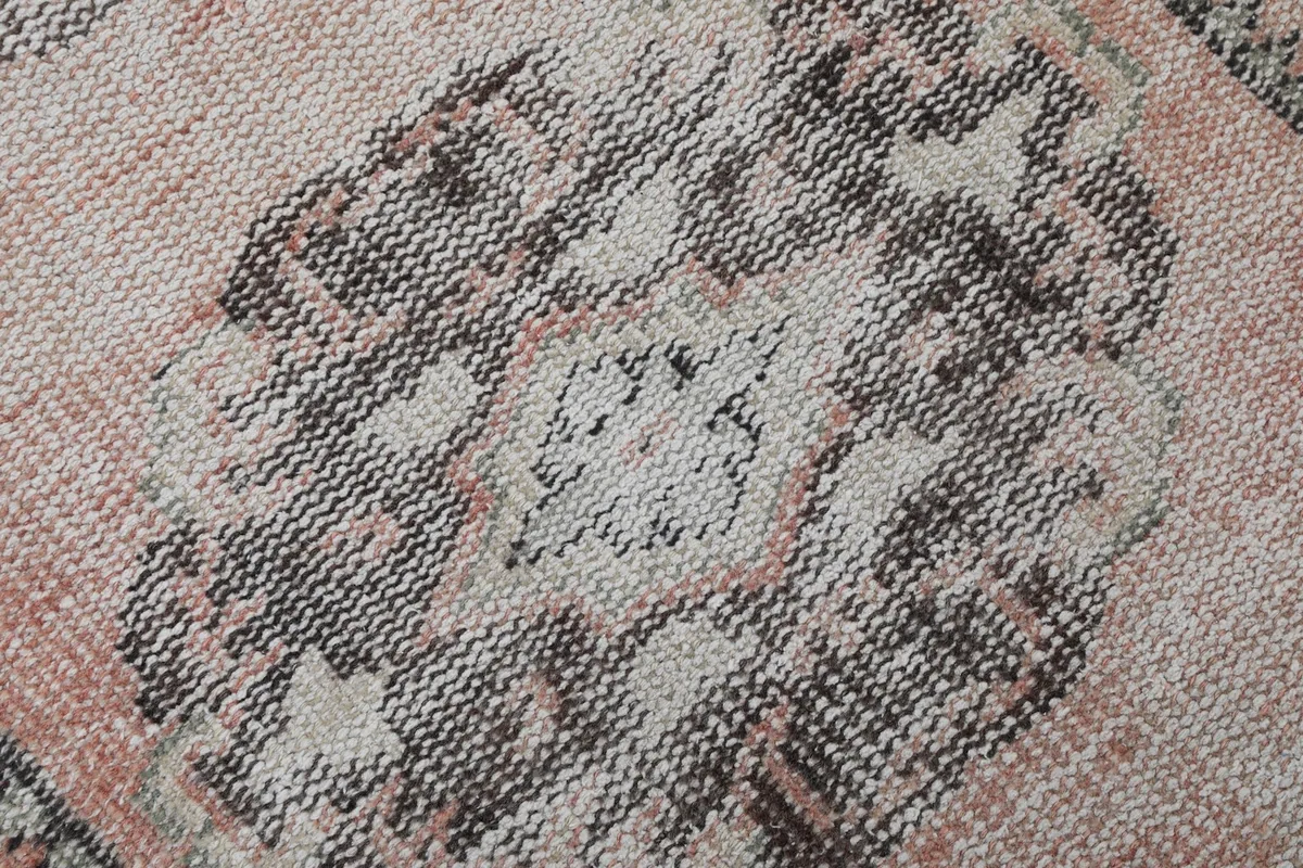 Close-up of a faded gray medallion pattern on the rose field, showing texture and wear