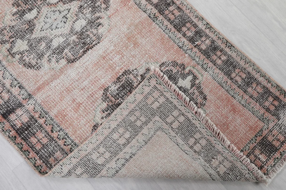 Folded corner revealing the back of the hand-knotted wool runner and cotton foundation