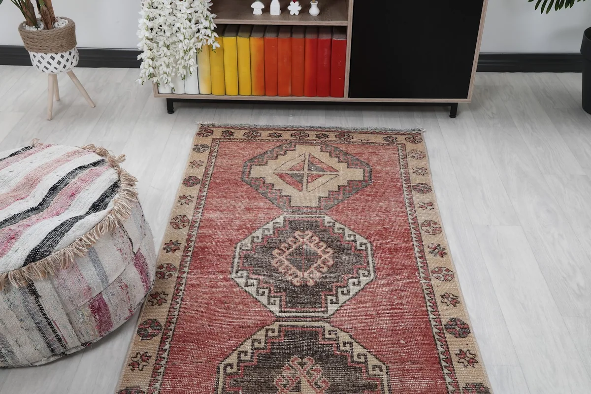 View of the runner rug extending into a room, with a decorative pouf in the foreground