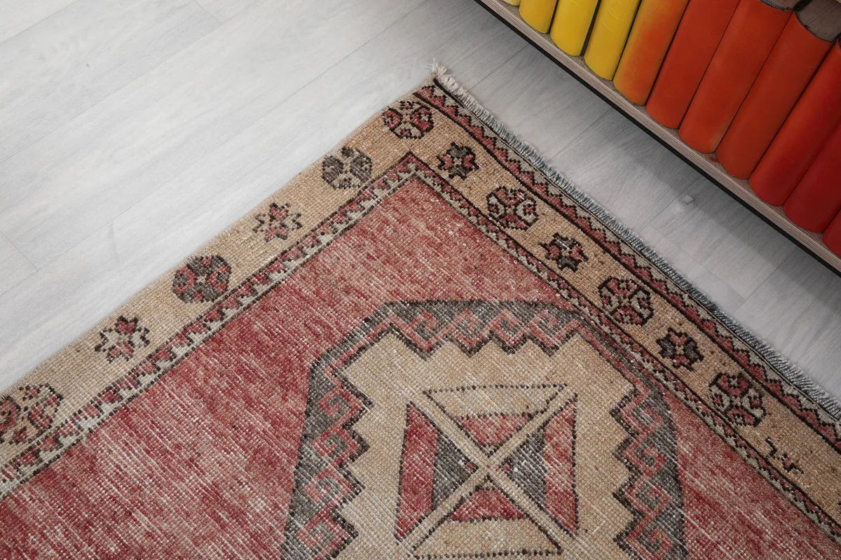 Corner detail of the runner rug, highlighting the beige border with small decorative elements