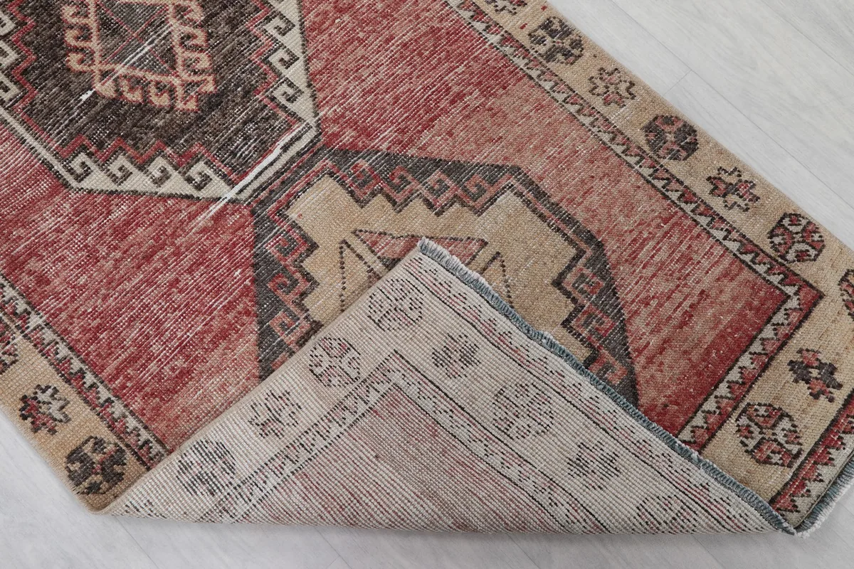 Close-up showing the low wool pile and hand-knotted construction of the vintage rug