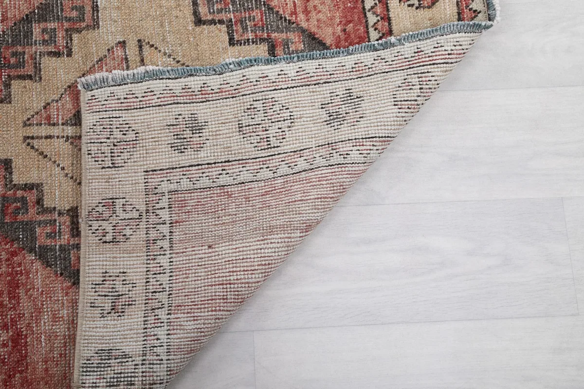 View of the reverse side of the runner rug, showing the cotton foundation