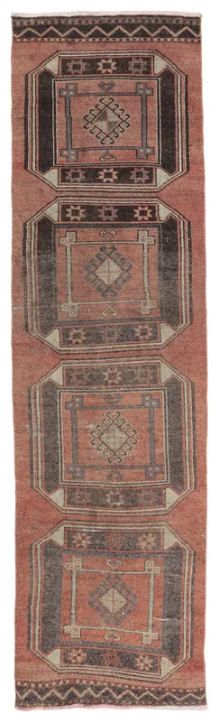 Full overhead view of the rust and charcoal geometric vintage runner rug on a white background.