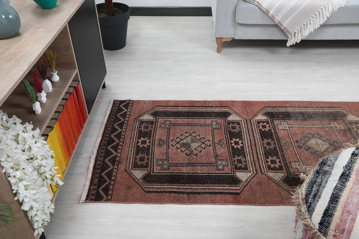 View of the runner rug from a higher angle in the room, showing part of a console table and couch.