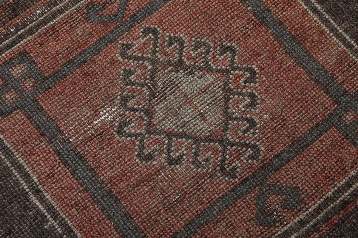 Close-up of a central geometric motif within one of the medallions, showing weave and subtle wear.
