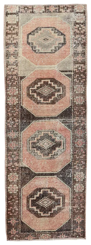 Full top view of the vintage rose and brown geometric runner rug on a white background