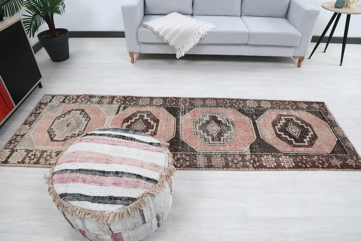 Full length view of the runner rug in a room with a sofa and ottoman
